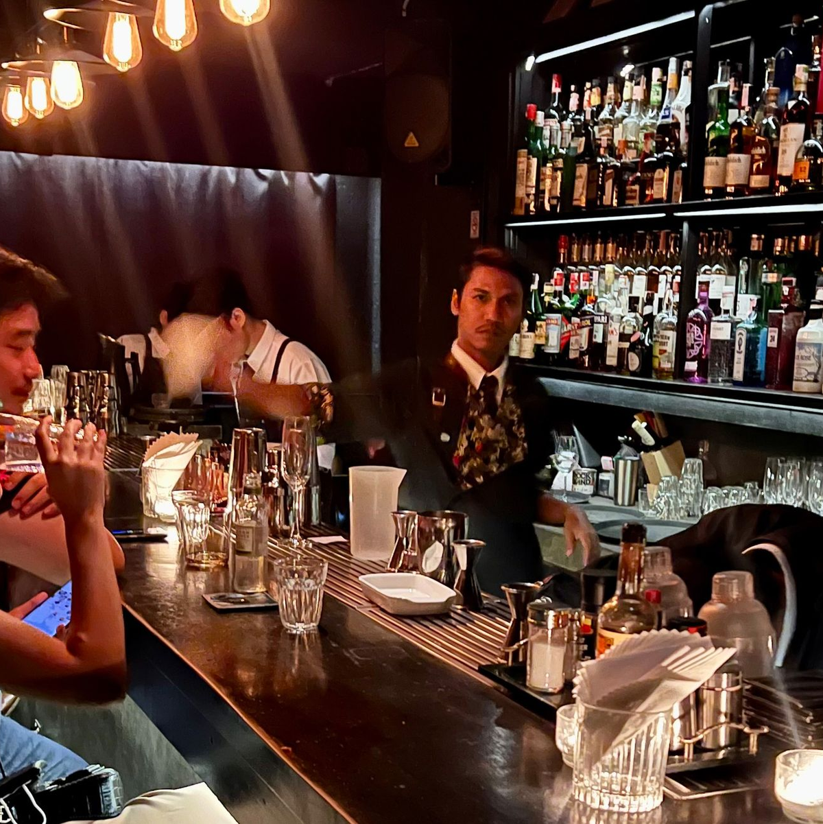 Gäste sitzen am Tresen einer Bar in Bangkok. - Foto: Carola Frentzen/dpa