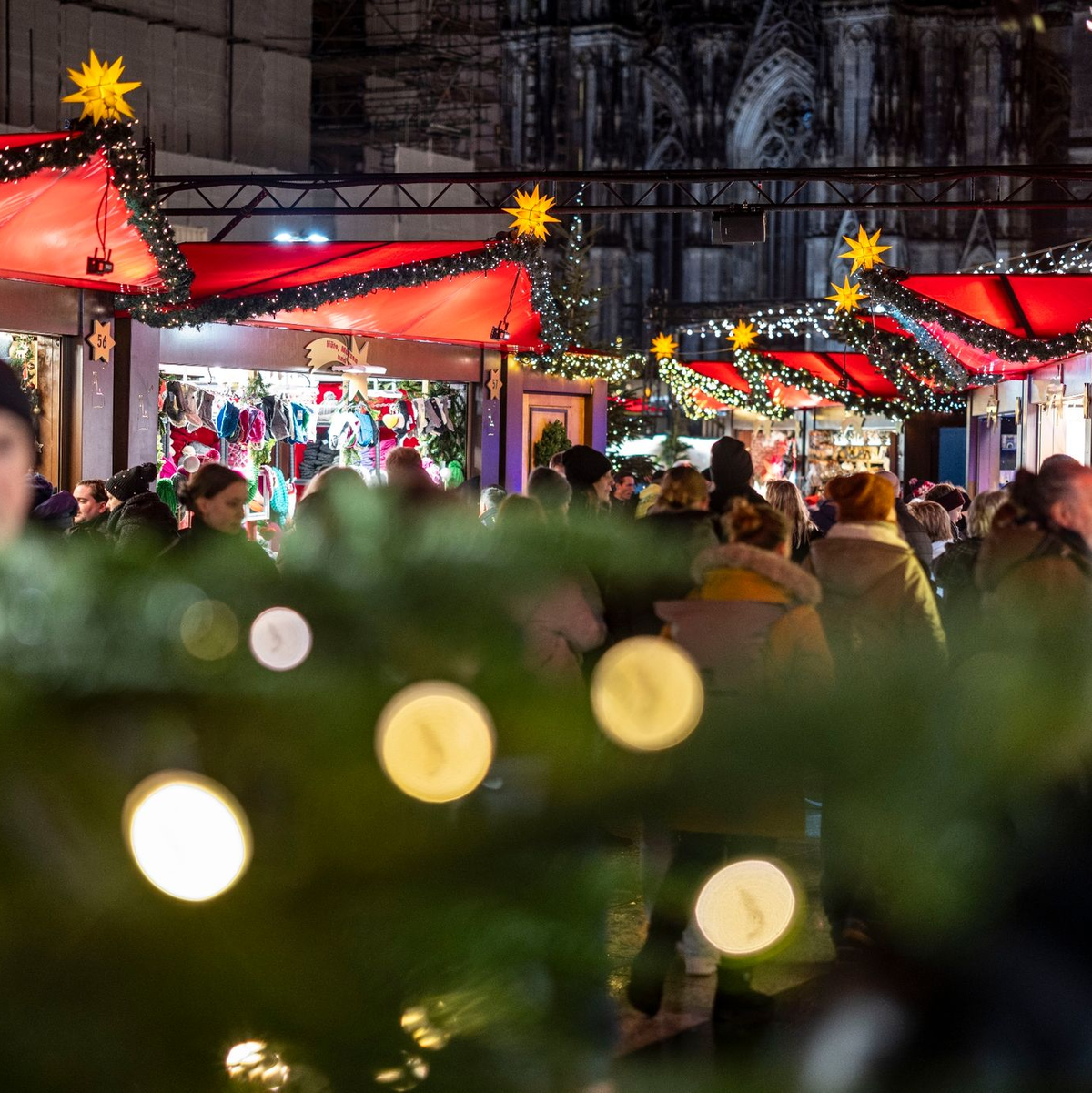 Der Weihnachtsmarkt am Kölner Dom ist am Abend gut besucht. - Foto: Christoph Reichwein/dpa