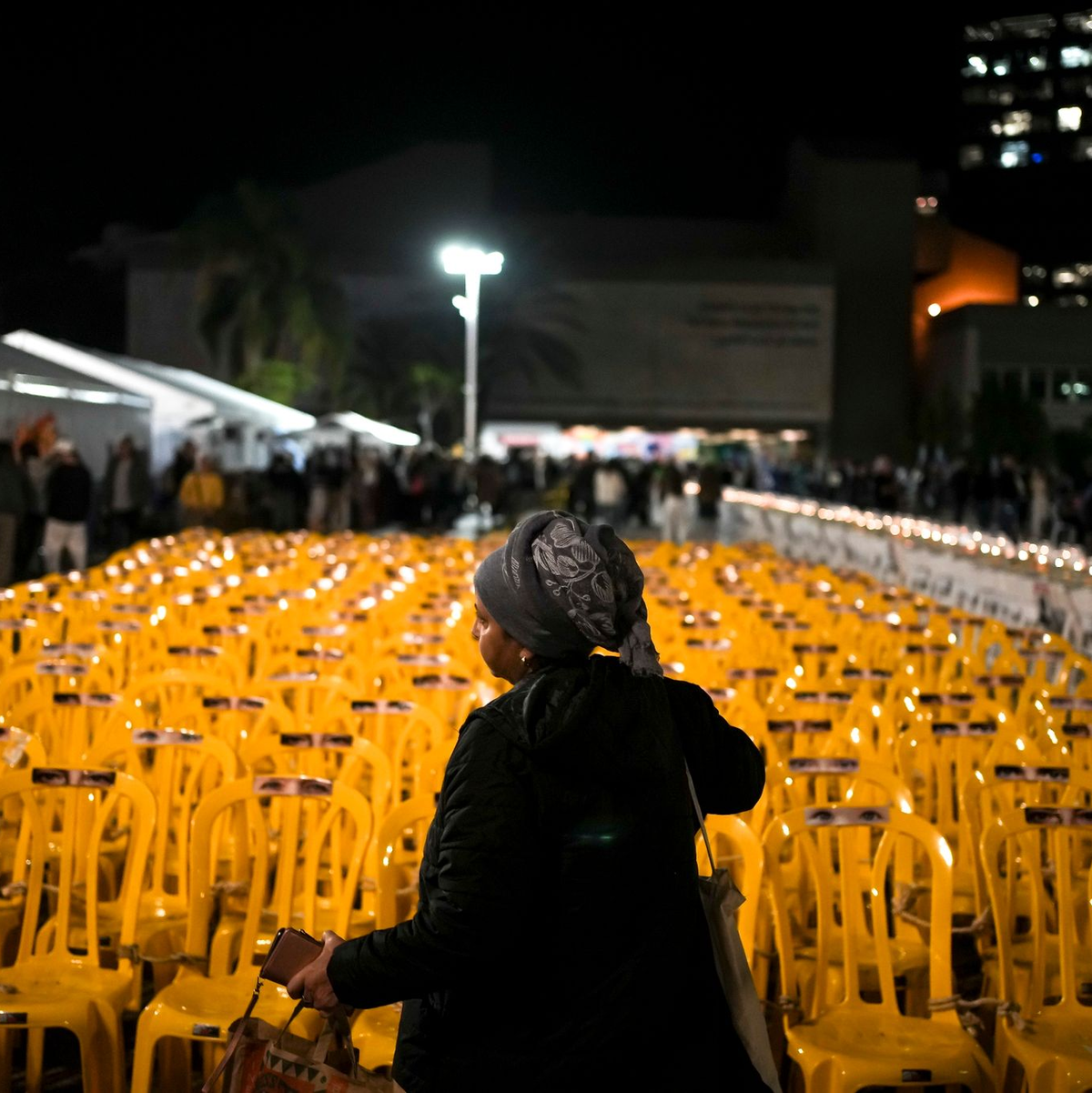 Stühle, auf denen Bilder mit menschlichen Augen angebracht sind: Mit der Kunstinstallation in Tel Aviv wird der Geiseln gedacht, die von der Hamas festgehalten werden. - Foto: Maya Alleruzzo/AP/dpa