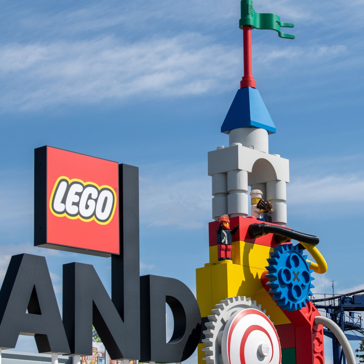 Neben dem Logo am Eingang zum Legoland ist eine Achterbahn zu sehen. - Foto: Stefan Puchner/dpa