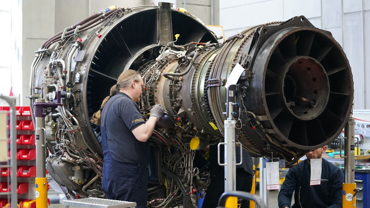 Mitarbeiter arbeiten an einer Flugzeugturbine in der Triebwerksüberholungswerkstatt auf dem Gelände der Lufthansa Technik AG. - Foto: Marcus Brandt/dpa