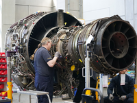 Mitarbeiter arbeiten an einer Flugzeugturbine in der Triebwerksüberholungswerkstatt auf dem Gelände der Lufthansa Technik AG. - Foto: Marcus Brandt/dpa