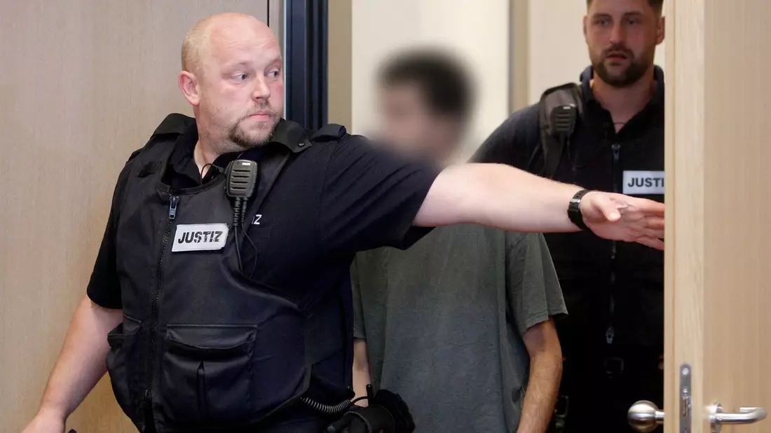 Der Hauptangeklagte wird von Justizbeamten in den Gerichtssaal geführt. - Bild: Roland Weihrauch/dpa