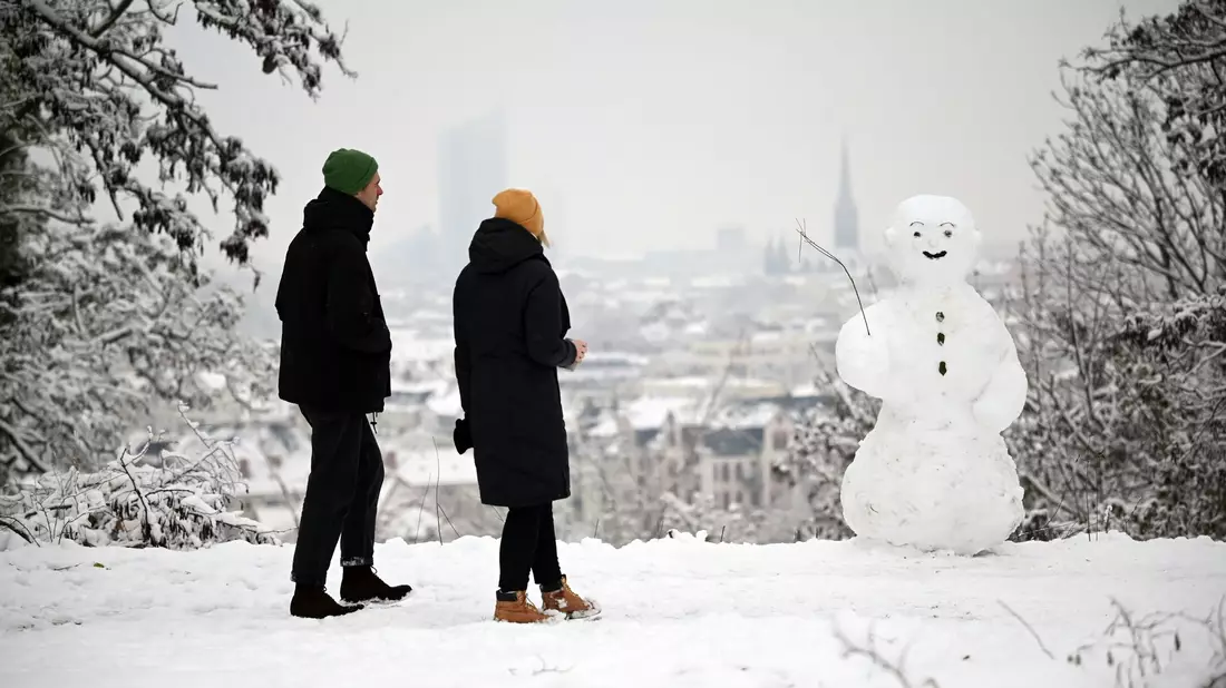 Zwei Spaziergänger wandern am Fockeberg (Leipzig) an einem Schneemann vorbei. - Bild: Patricia Bartos/dpa