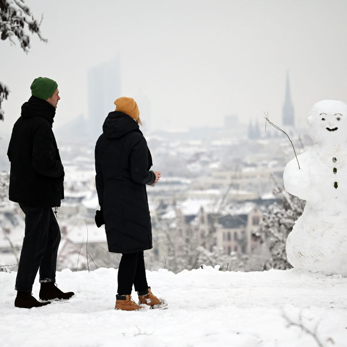 Zwei Spaziergänger wandern am Fockeberg (Leipzig) an einem Schneemann vorbei. - Foto: Patricia Bartos/dpa