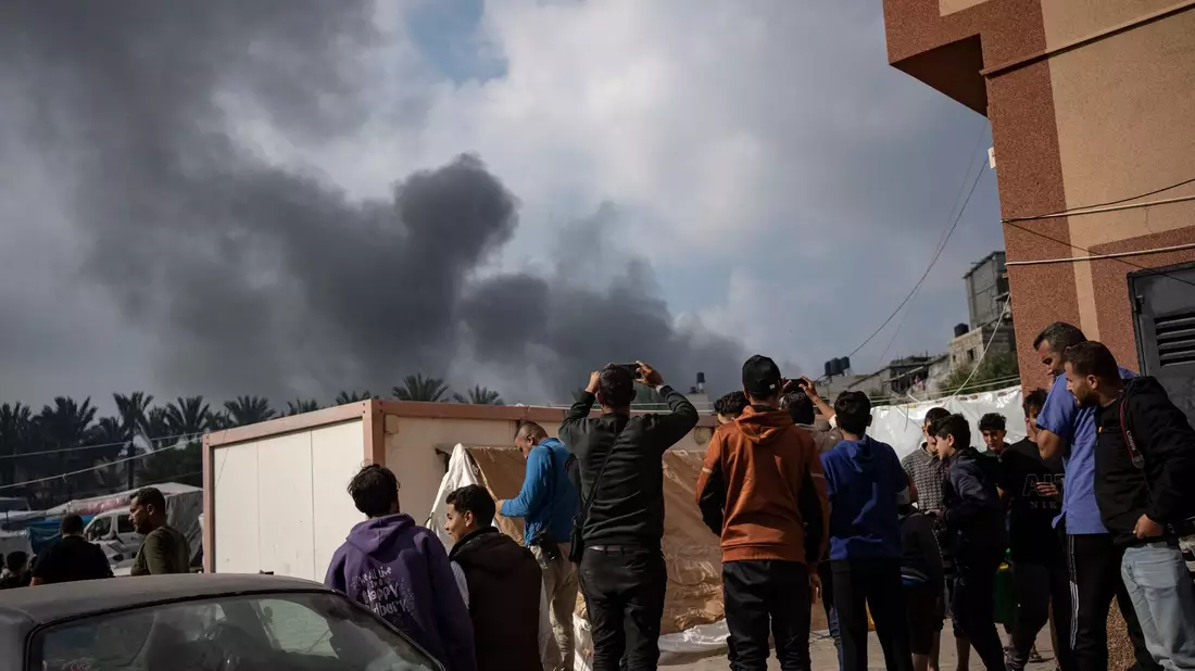 Palästinenser in Chan Junis betrachten den aufsteigenden Rauch nach einem israelischen Luftangriff. - Bild: Fatima Shbair/AP/dpa