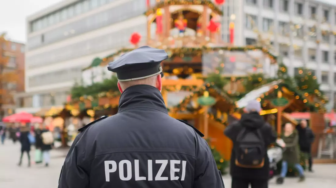 Ein Polizist steht an der Weihnachtspyramide am Kröpcke in Hannover. In Niedersachsen ist ein 20-Jähriger festgenommen worden, der einen Terroranschlag in der Weihnachtszeit geplant haben soll. - Bild: Julian Stratenschulte/dpa