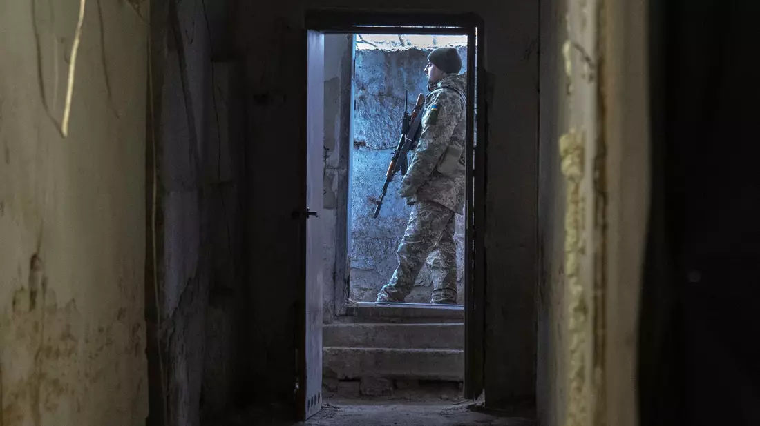 Ein ukrainischer Soldat steht vor einem Unterstand in der Frontstadt in der Region Charkiw. - Bild: Efrem Lukatsky/AP