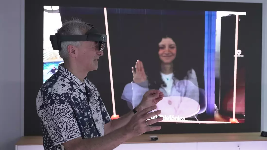 O2-Innovationsmanager Karsten Erlebach spricht via VR-Brille mit seiner Kollegin, die er in der Brille plastisch als Hologramm sieht. - Bild: Barbaros Bulgurcu/o2 Telefonica/dpa