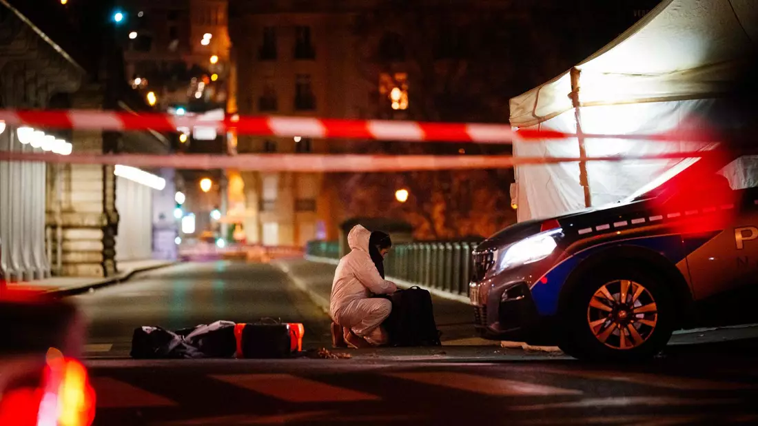 Ein Beamter der Kriminalpolizei arbeitet am Tatort unweit des Eiffelturms in Paris. - Bild: Dimitar Dilkoff/AFP/dpa