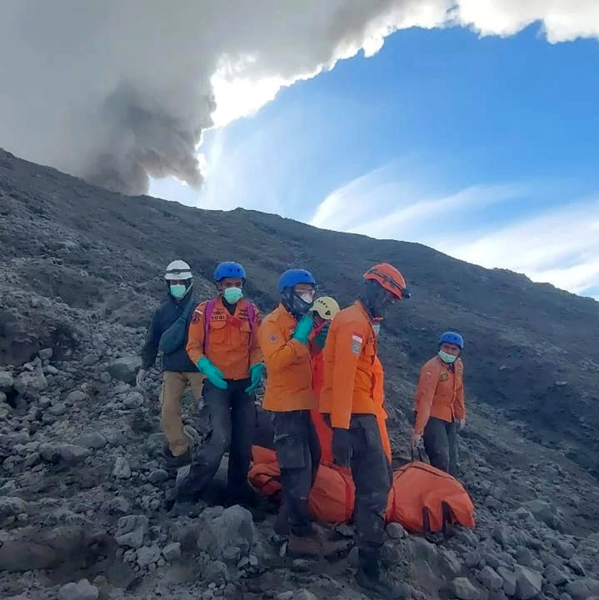 Rettungskräfte bereiten sich darauf vor, die Leiche eines Bergsteigers zu bergen, der beim Ausbruch des Vulkans Marapi ums Leben gekommen ist. - Foto: BASARNAS/BASARNAS/AP/dpa