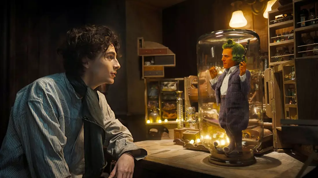 Timothee Chalamet (l) als Willy Wonka und Hugh Grant als Oompa Loompa in einer Szene des Films Wonka. - Bild: Warner Bros. Picture/dpa