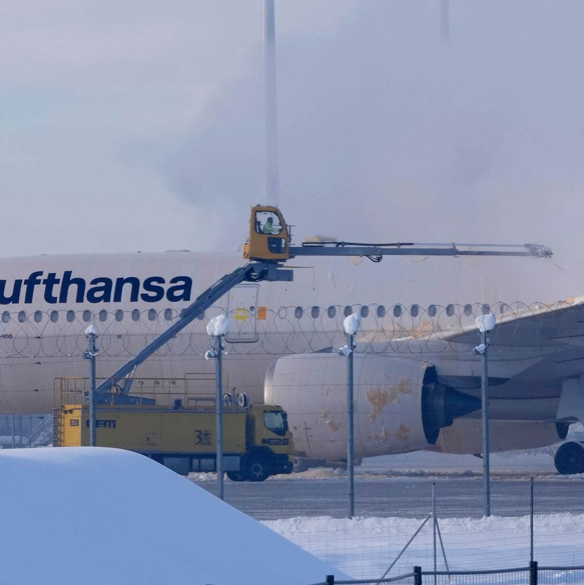 Ein Flugzeug der Lufthansa wird auf dem Flughafen München enteist. - Foto: Matthias Schrader/AP/dpa