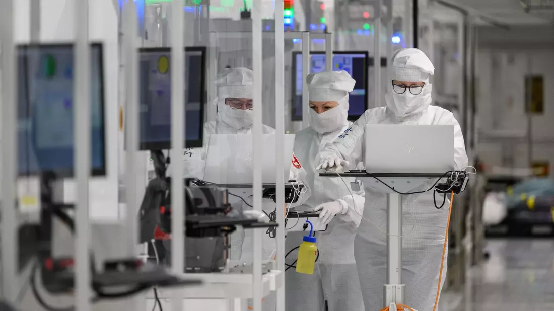 Mitarbeiter des Chipkonzerns Infineon arbeiten im Reinraum der Chipfabrik. - Bild: Robert Michael/dpa