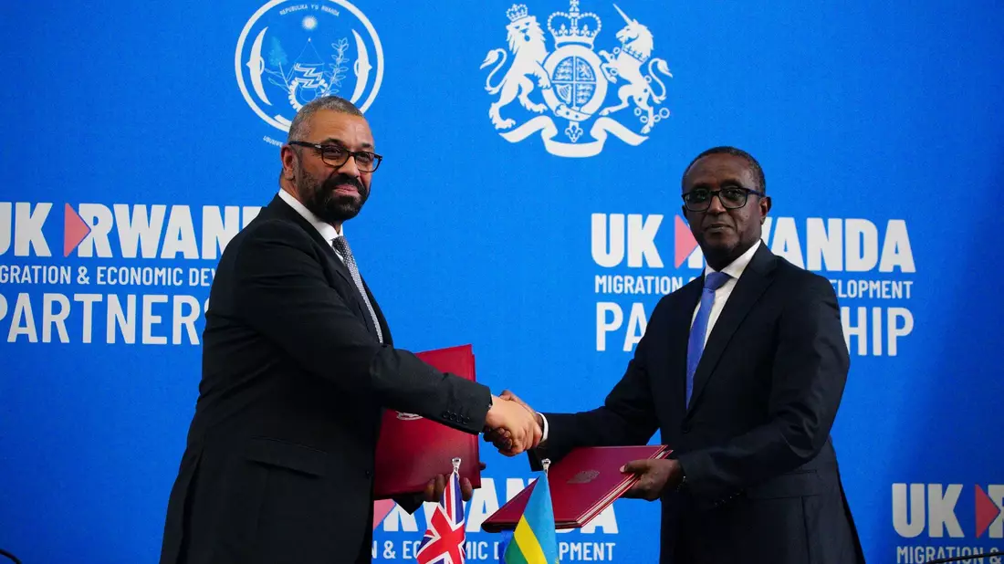Großbritanniens Innenminister James Cleverly (l) und Vincent Birut, Außenminister von Ruanda, schütteln sich die Hände. Mit dem neuen Vertrag will die britische Regierung Asylsuchende künftig in das ostafrikanische Land abschieben. - Bild: Ben Birchall/Pool PA/AP/dpa