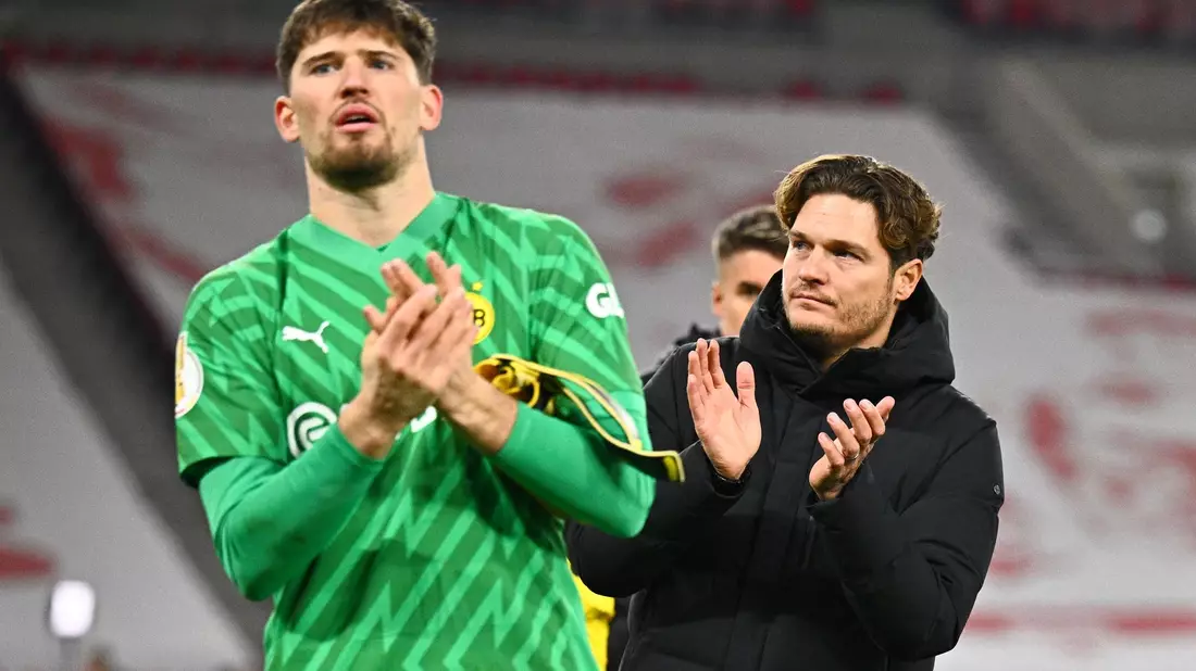 Dortmunds Torwart Gregor Kobel (l) und Trainer Edin Terzic verabscheden sich nach dem Pokal-Aus von den Fans. - Bild: Tom Weller/dpa