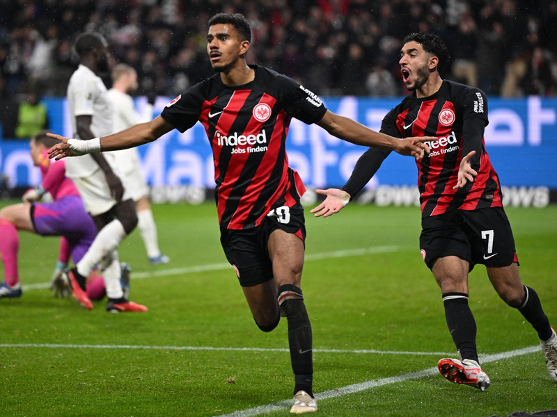 Abreibung für die Tuchel-Elf: Frankfurts Ansgar Knauff (l) und Omar Marmoush jubeln über das 5:1. - Foto: Arne Dedert/dpa