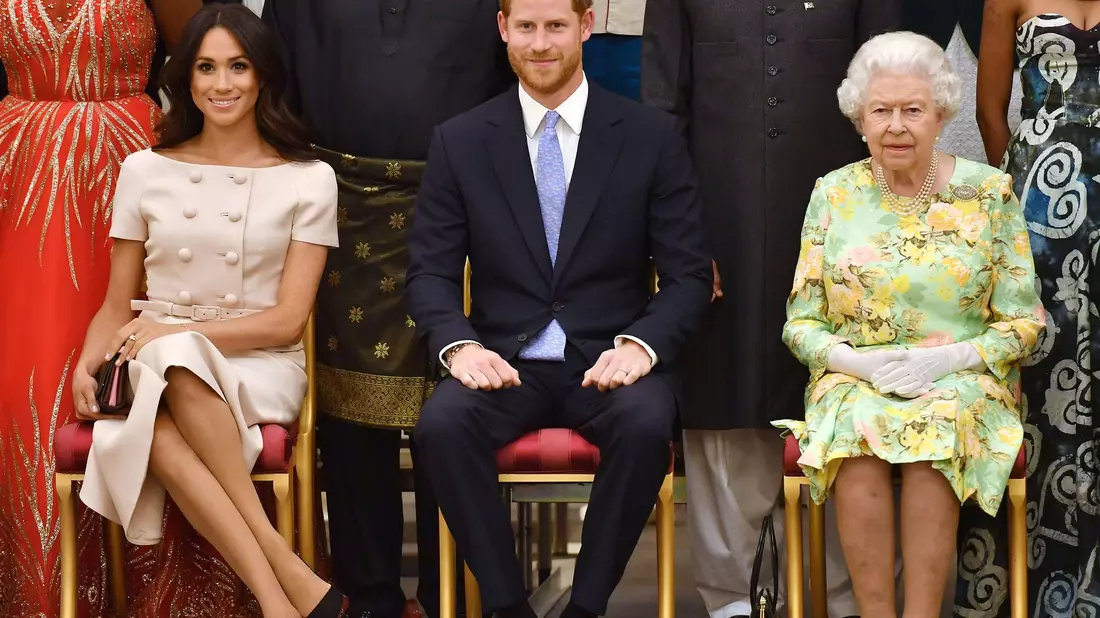 Die britische Königin Elizabeth II., Prinz Harry und seine Frau Meghan auf einer Aufnahme aus dem Sommer 2018. - Bild: John Stillwell/PA Wire/dpa