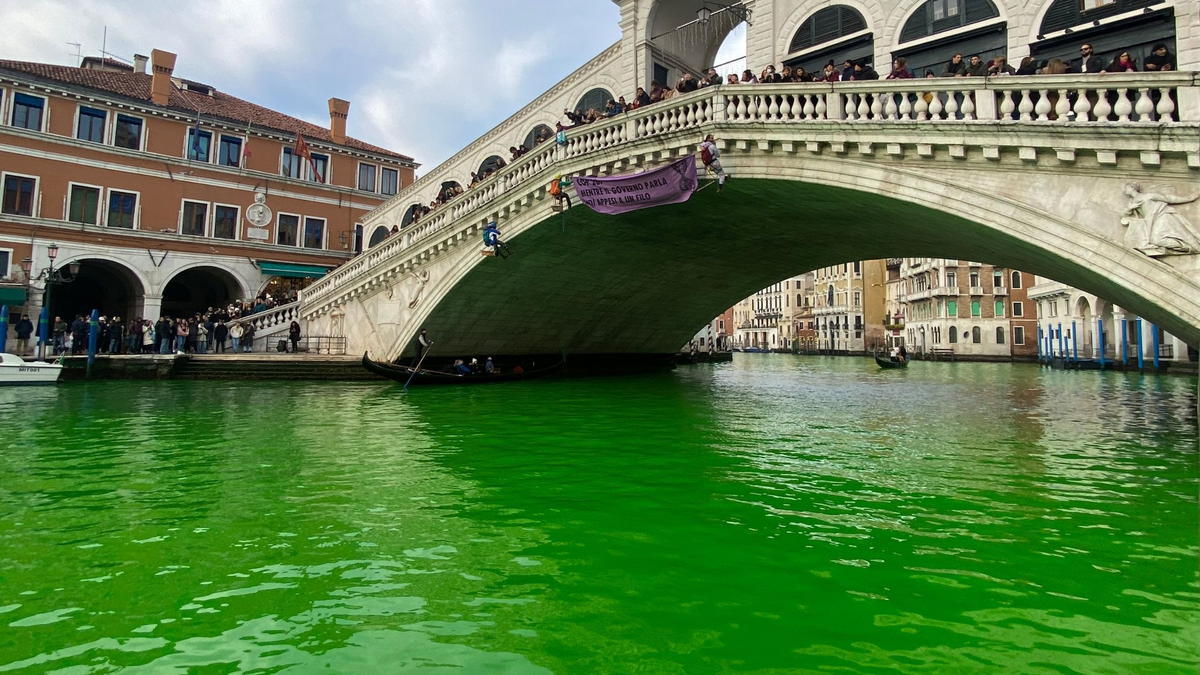 Das Wasser des Canal Grande unter der Rialto-Brücke in Venedig ist leuchtend grün gefärbt. - Foto: ---/Extinction Rebellion Venezia/dpa