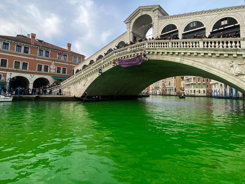 Das Wasser des Canal Grande unter der Rialto-Brücke in Venedig ist leuchtend grün gefärbt. - Foto: ---/Extinction Rebellion Venezia/dpa