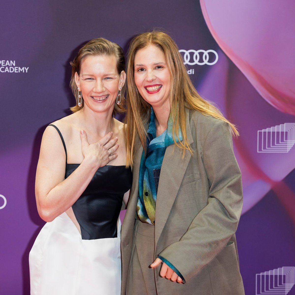 Schauspielerin Sandra Hüller und Drehbuchautorin und Regisseurin Justine Triet (r) auf dem roten Teppich in Berlin. - Foto: Christoph Soeder/dpa