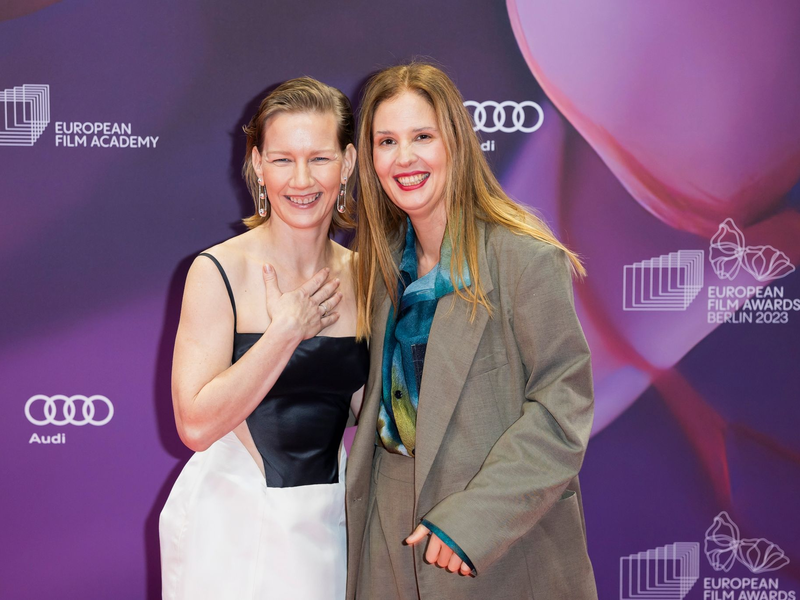 Schauspielerin Sandra Hüller und Drehbuchautorin und Regisseurin Justine Triet (r) auf dem roten Teppich in Berlin. - Foto: Christoph Soeder/dpa