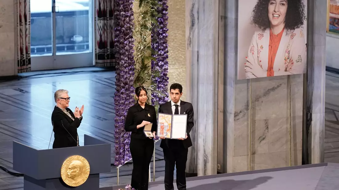Kiana (l) und Ali Rahmani halten die Medaille und die Urkunde während der Verleihung des Friedensnobelpreises 2023 im Rathaus von Oslo. Die Zwillinge nehmen den Friedensnobelpreis stellvertretend für ihre inhaftierte Mutter entgegen. - Bild: Fredrik Varfjell/NTB/dpa