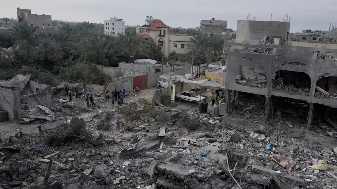 Palästinenser betrachten die Trümmer eines Gebäudes im Zenrum des Gazastreifens, das bei einer israelischen Bombardierung zerstört wurde. - Bild: Hatem Moussa/AP/dpa