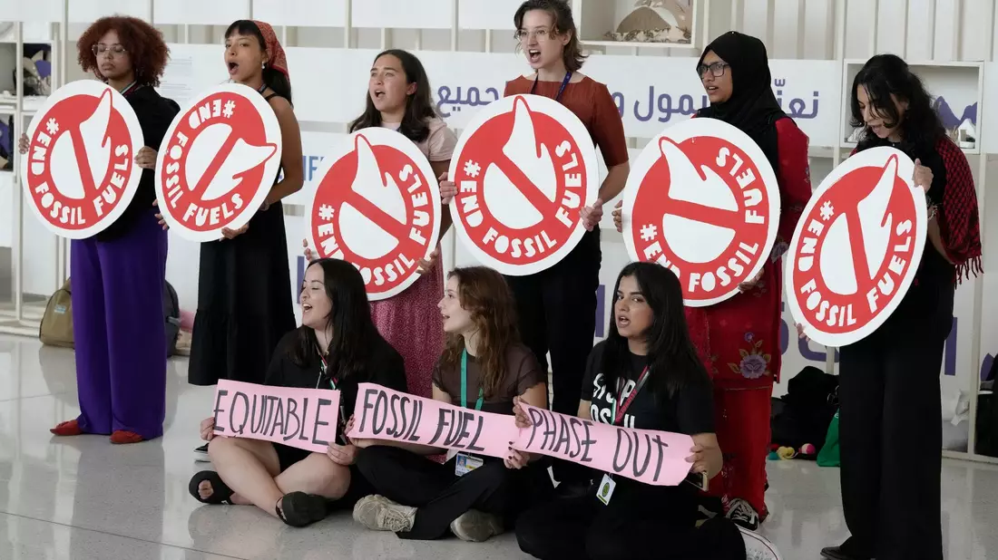 Aktivistinnen fordern in Dubai den Ausstieg aus fossilen Brennstoffen. - Bild: Peter Dejong/AP/dpa