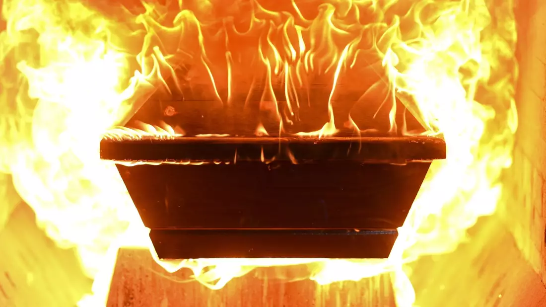 Ein Sarg fängt Feuer, nachdem er in den Ofen des Krematoriums hineingefahren wurde. - Bild: Felix Kästle/dpa