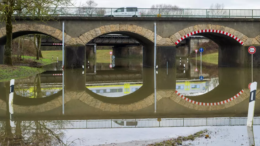 An der Schmutter in Donauwörth ist kurz vor der Mündung in die Donau eine Straße überflutet. - Bild: Stefan Puchner/dpa