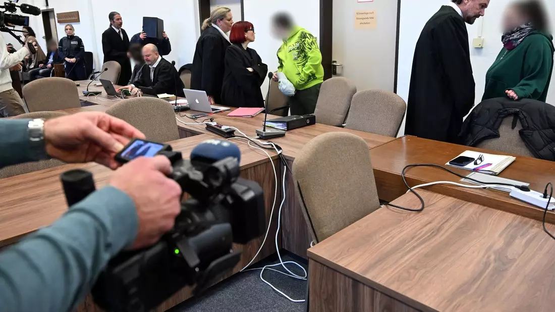 Die Angeklagten warten mit ihren Rechtsanwälten auf den Beginn des Prozesses in Köln. - Bild: Federico Gambarini/dpa