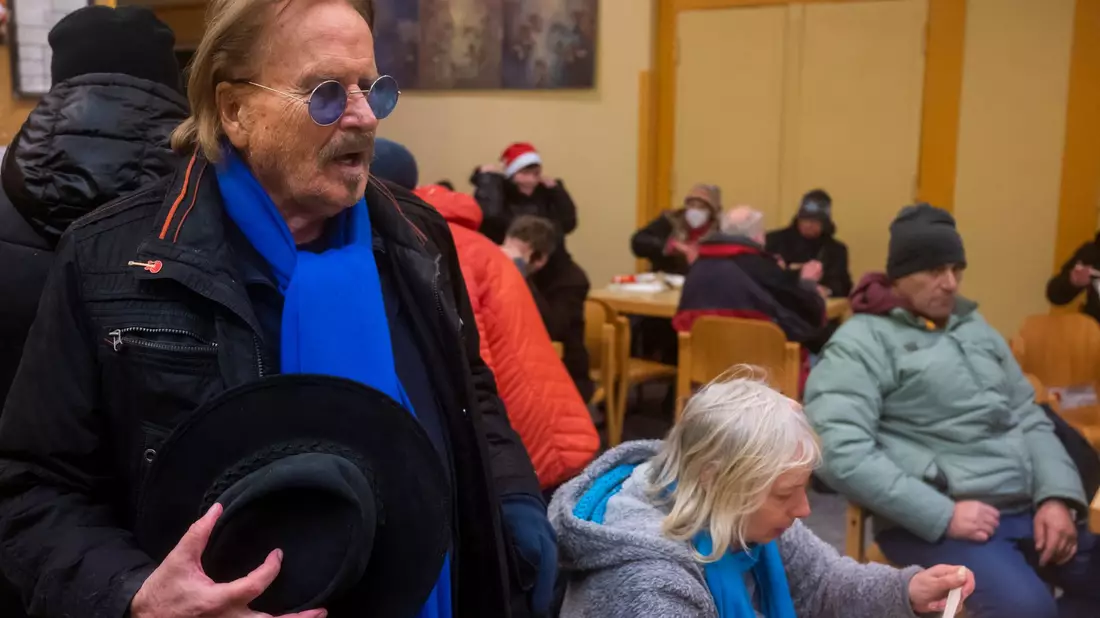 Frank Zander spricht mit Obdachlosen und Bedürftigen bei einem Weihnachtsessen. (Archivbild) - Bild: Christophe Gateau/dpa