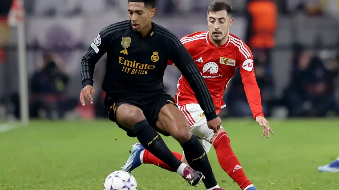 Reals Jude Bellingham (l) schirmt den Ball vor dem Unioner Josip Juranovic ab. - Bild: Andreas Gora/dpa