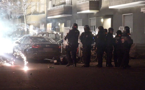Polizisten stehen in der Silvesternacht 2022 hinter explodierendem Feuerwerk in Berlin. - Foto: Julius-Christian Schreiner/TNN/dpa