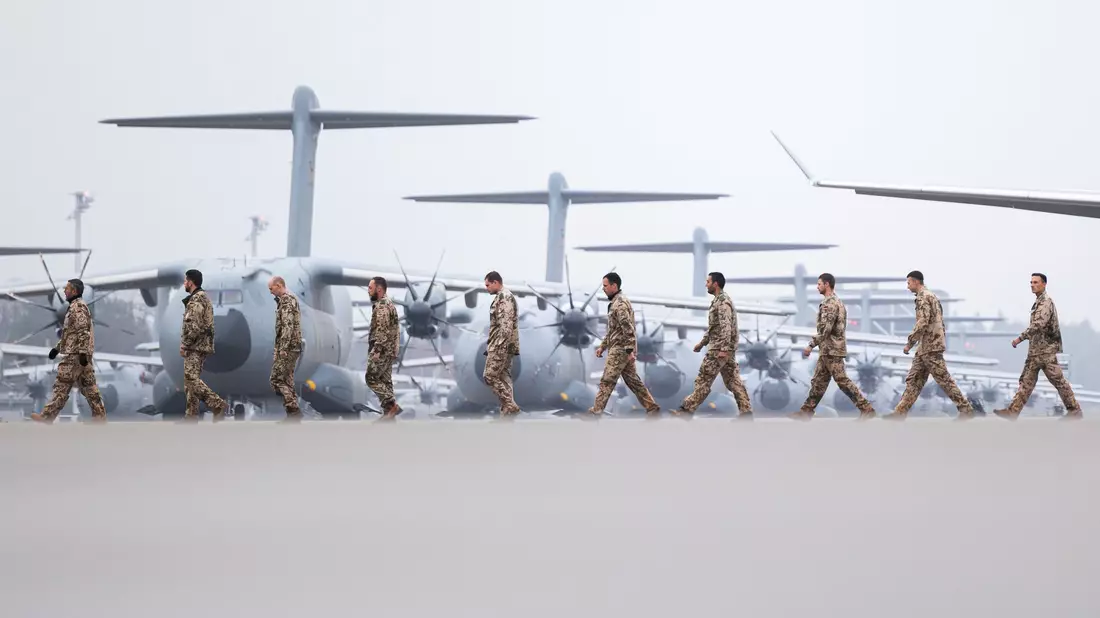 Soldaten laufen nach der Landung über das Gelände vom Fliegerhorst Wunstorf. - Bild: Michael Matthey/dpa