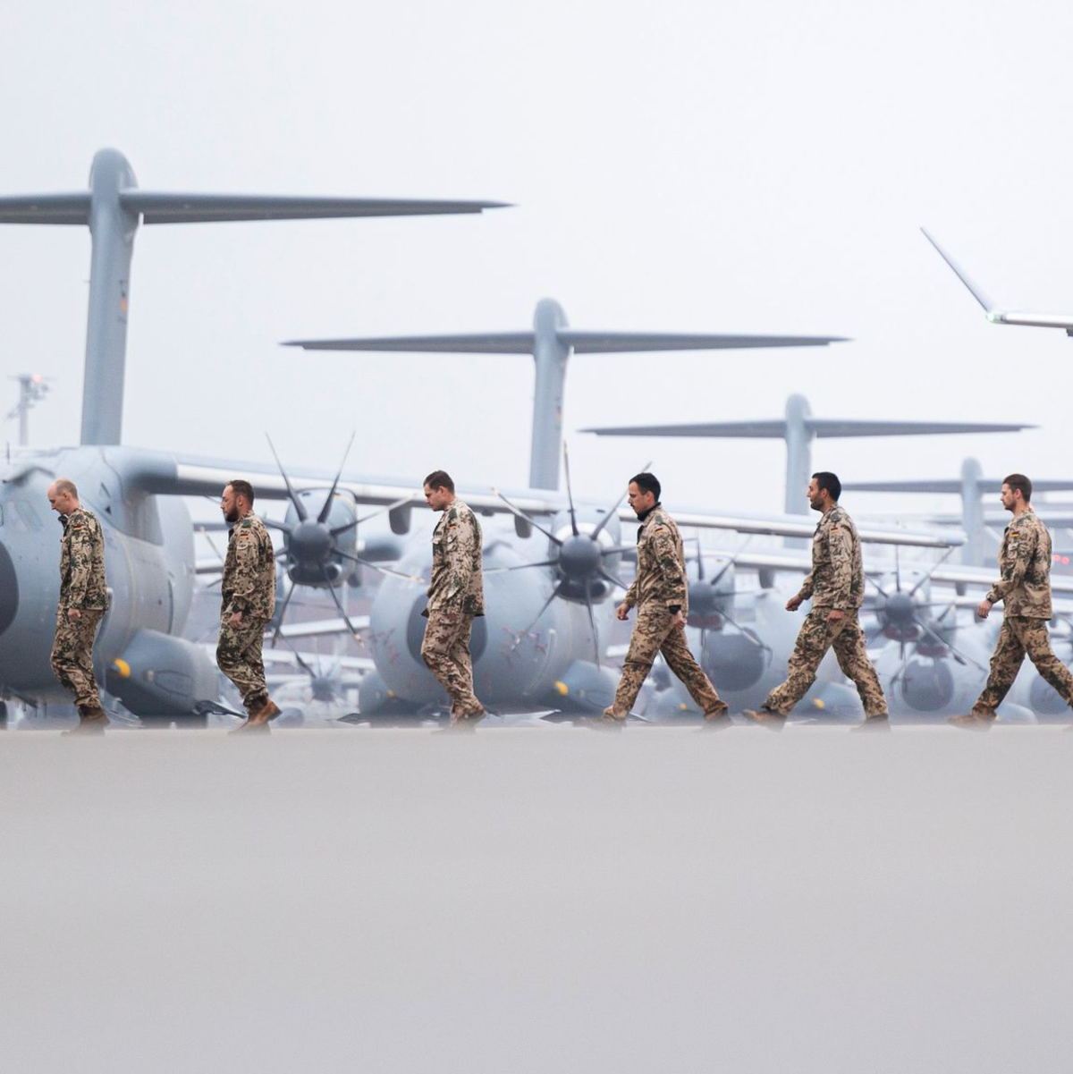 Soldaten laufen nach der Landung über das Gelände vom Fliegerhorst Wunstorf. - Foto: Michael Matthey/dpa