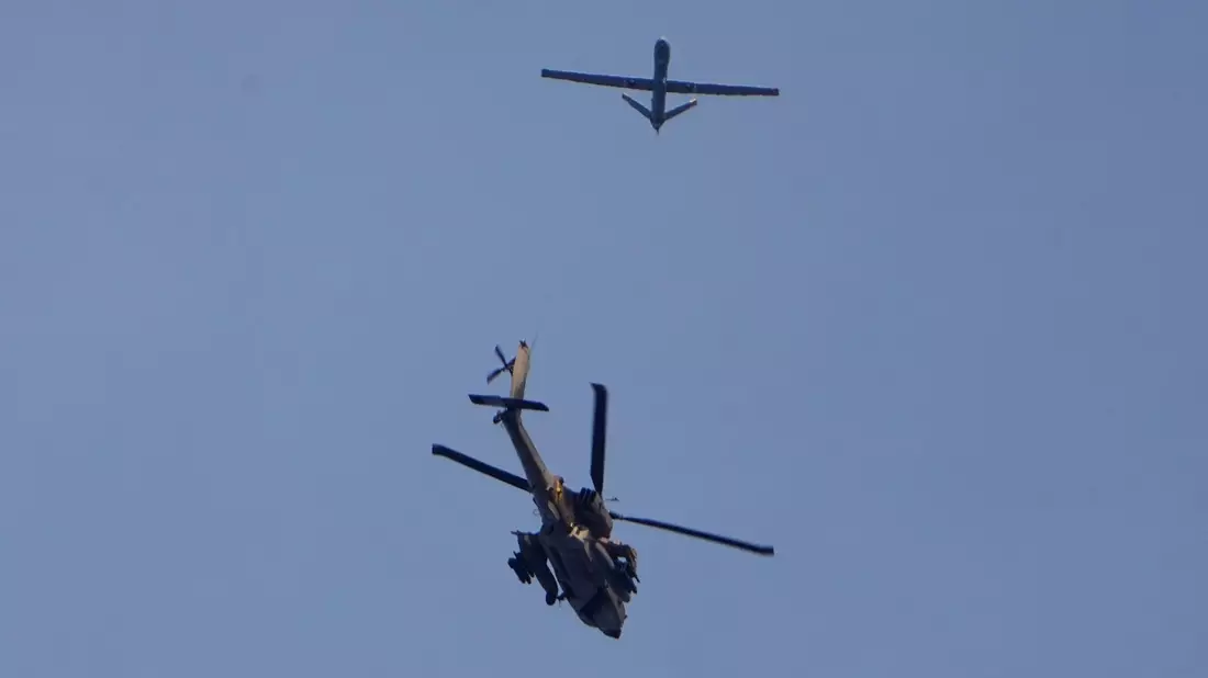 In der Nähe des Gazastreifens: ein israelischer Apache-Hubschrauber und eine Drohne. - Bild: Ariel Schalit/AP