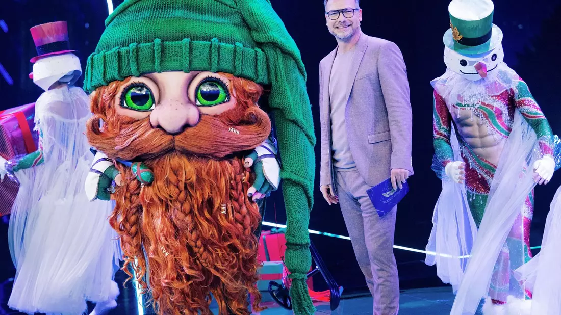 Die Figur «Klaus Claus» in der Prosieben-Show The Masked Singer neben Moderator Matthias Opdenhövel. - Bild: Rolf Vennenbernd/dpa