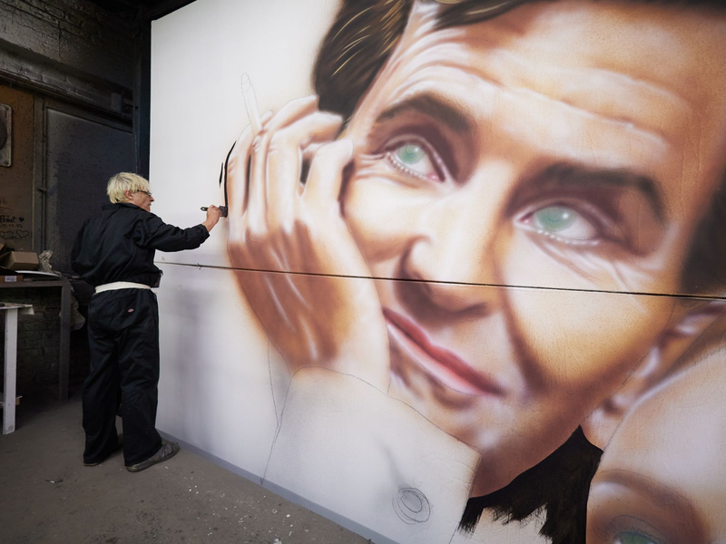 Mit dem gedruckten Original-Plakat als Vorlage malt Valien das Kinoplakat. - Foto: Jörg Carstensen/dpa