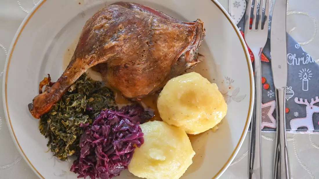 Das Weihnachtsessen nicht in Gefahr: Eine Entenkeule mit Klößen, Rotkohl und Grünkohl wird serviert. - Bild: Patrick Pleul/dpa