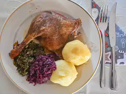 Das Weihnachtsessen nicht in Gefahr: Eine Entenkeule mit Klößen, Rotkohl und Grünkohl wird serviert. - Foto: Patrick Pleul/dpa