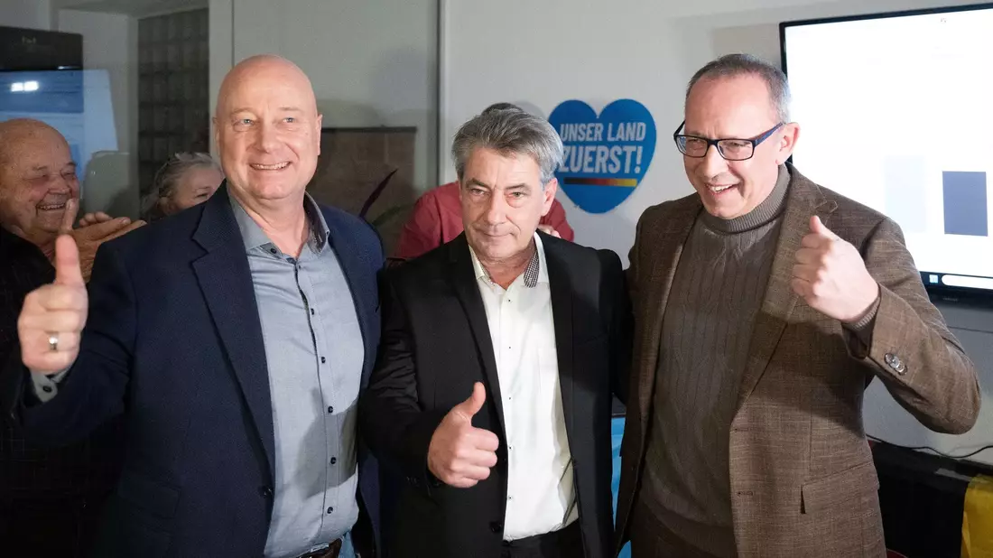 Der sächsische AfD-Generalsekretär Jan Zwerg (l-r), AfD-Kandidat Tim Lochner und der sächsische AfD-Vorsitzende Jörg Urban jubeln während der Wahlparty ihrer Partei. - Bild: Sebastian Kahnert/dpa