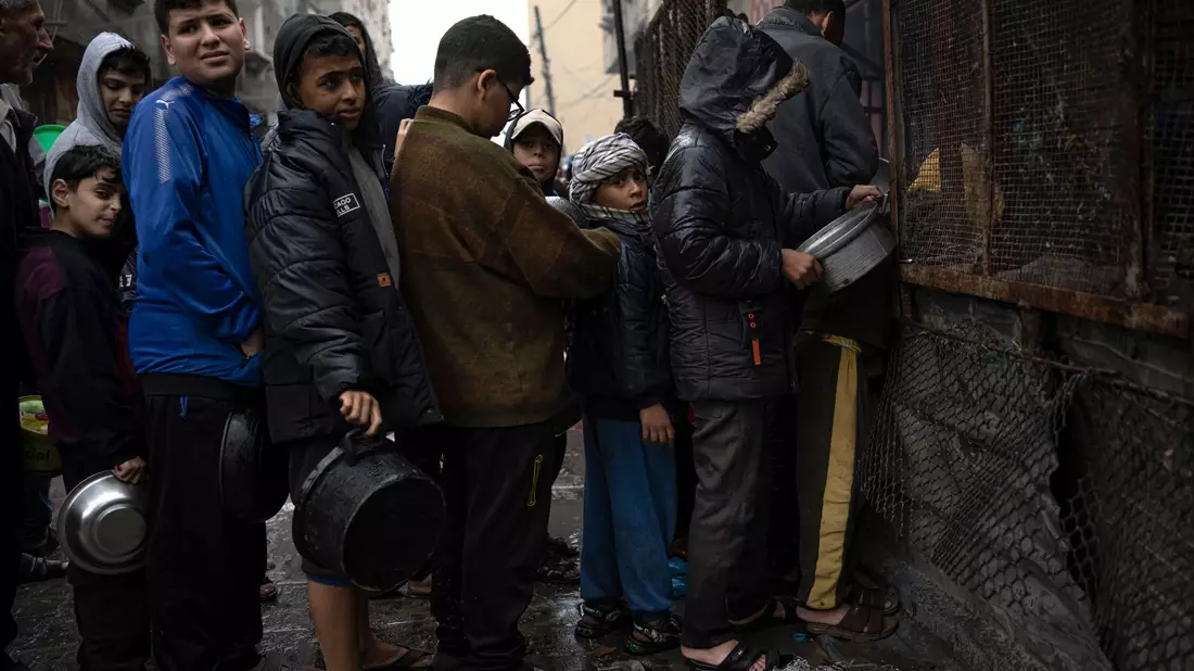 Kinder warten in Rafah auf die Ausgabe von Lebensmitteln. - Bild: Fatima Shbair/AP/dpa