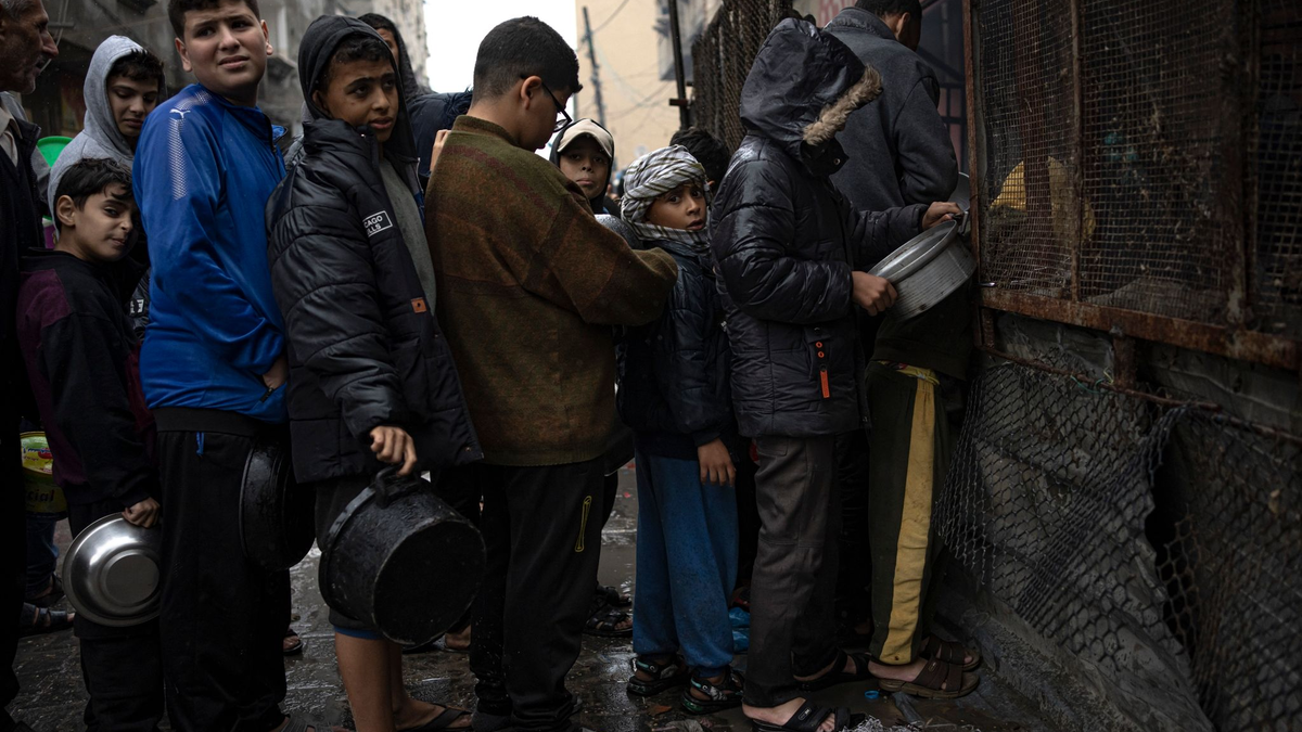 Kinder warten in Rafah auf die Ausgabe von Lebensmitteln. - Foto: Fatima Shbair/AP/dpa