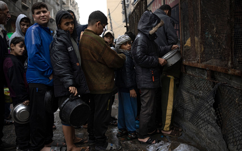 Kinder warten in Rafah auf die Ausgabe von Lebensmitteln. - Foto: Fatima Shbair/AP/dpa