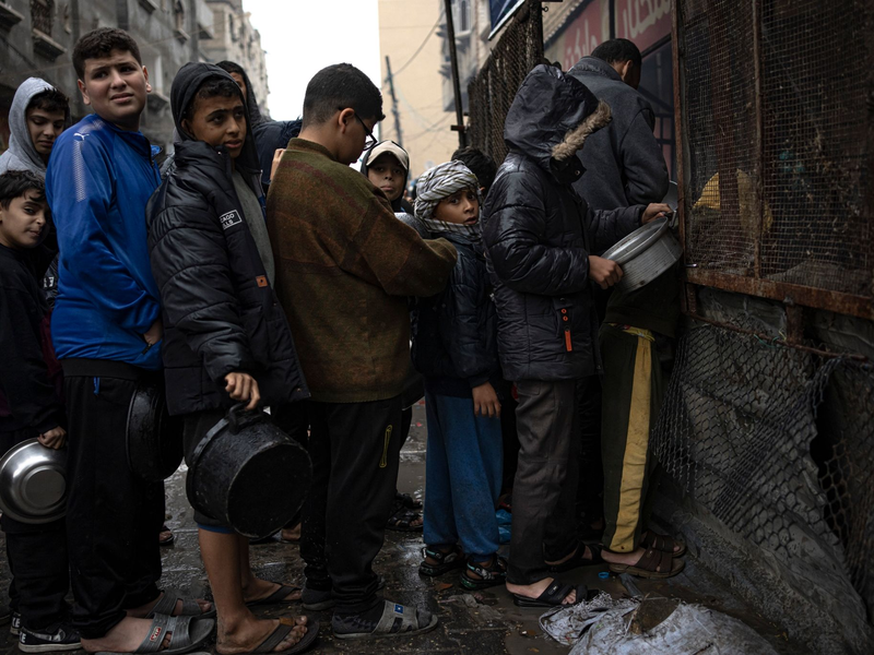Kinder warten in Rafah auf die Ausgabe von Lebensmitteln. - Foto: Fatima Shbair/AP/dpa