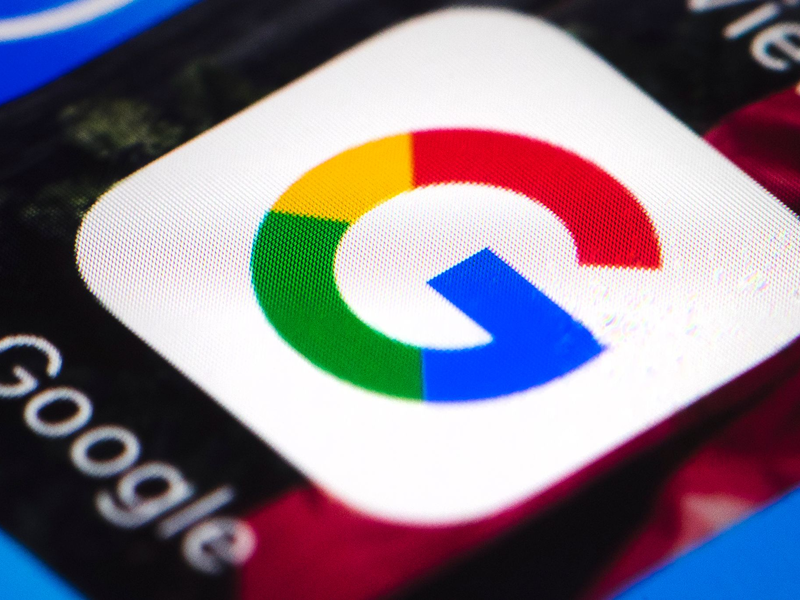 Das Google-Logo auf einem Smartphone. Google will in den USA nach einem App-Store-Vergleich Millionen zahlen. - Foto: Matt Rourke/dpa