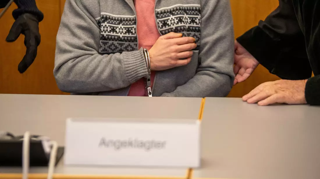Mit Handschellen gefesselt sitzt der Angeklagte im Ulmer Landgericht. - Bild: Stefan Puchner/dpa