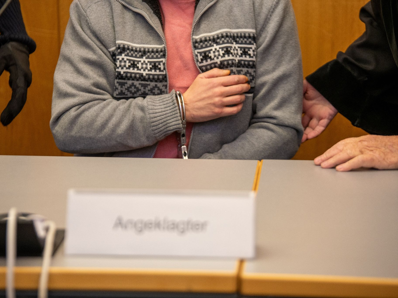 Mit Handschellen gefesselt sitzt der Angeklagte im Ulmer Landgericht. - Foto: Stefan Puchner/dpa